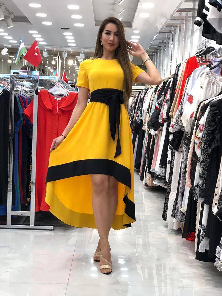 Abito svasato giallo asimmetrico Moda Mania con orlo alto e cintura nera, vestibilità elegante e stile moderno.