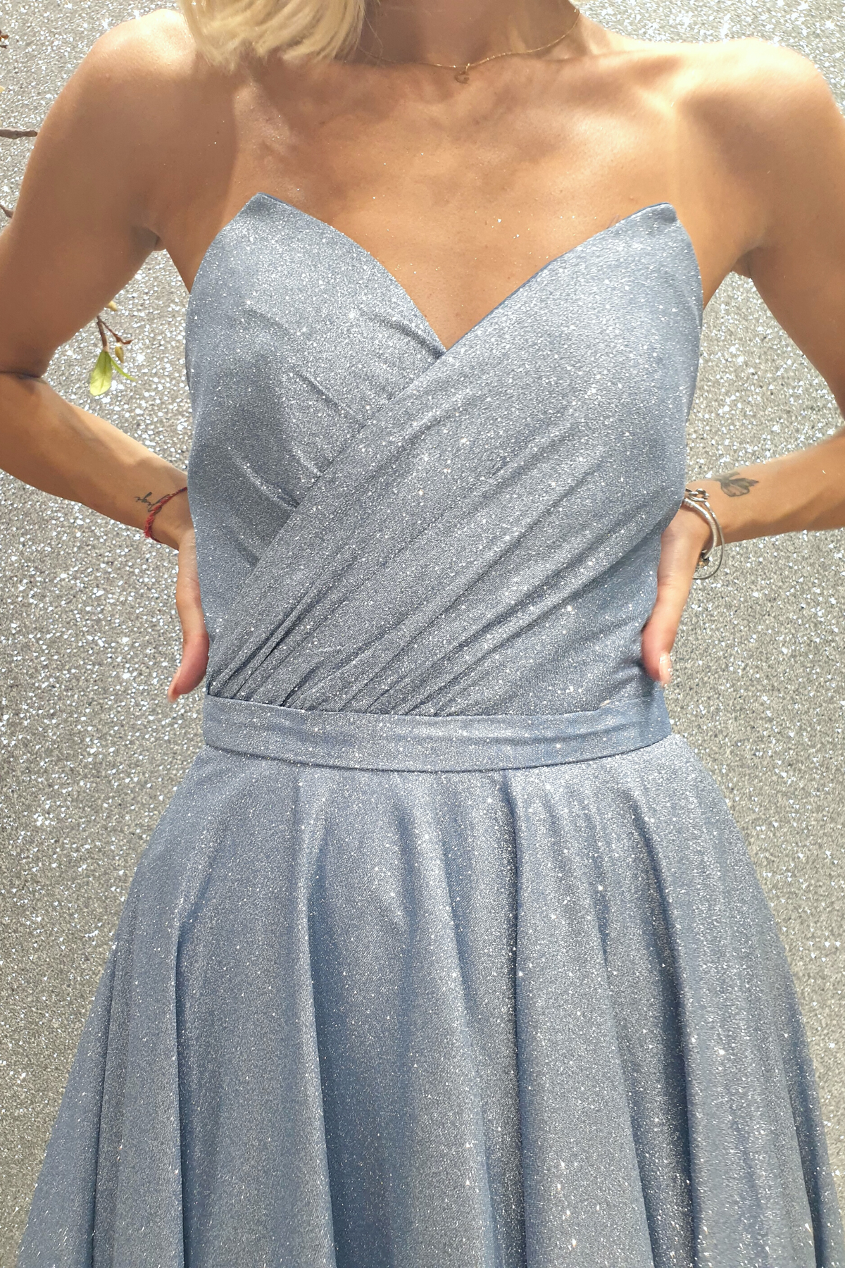 Abito lungo svasato in tessuto glitterato celeste con corpetto a cuore a punta e lunghezza asimmetrica, firmato Moda-Mania.