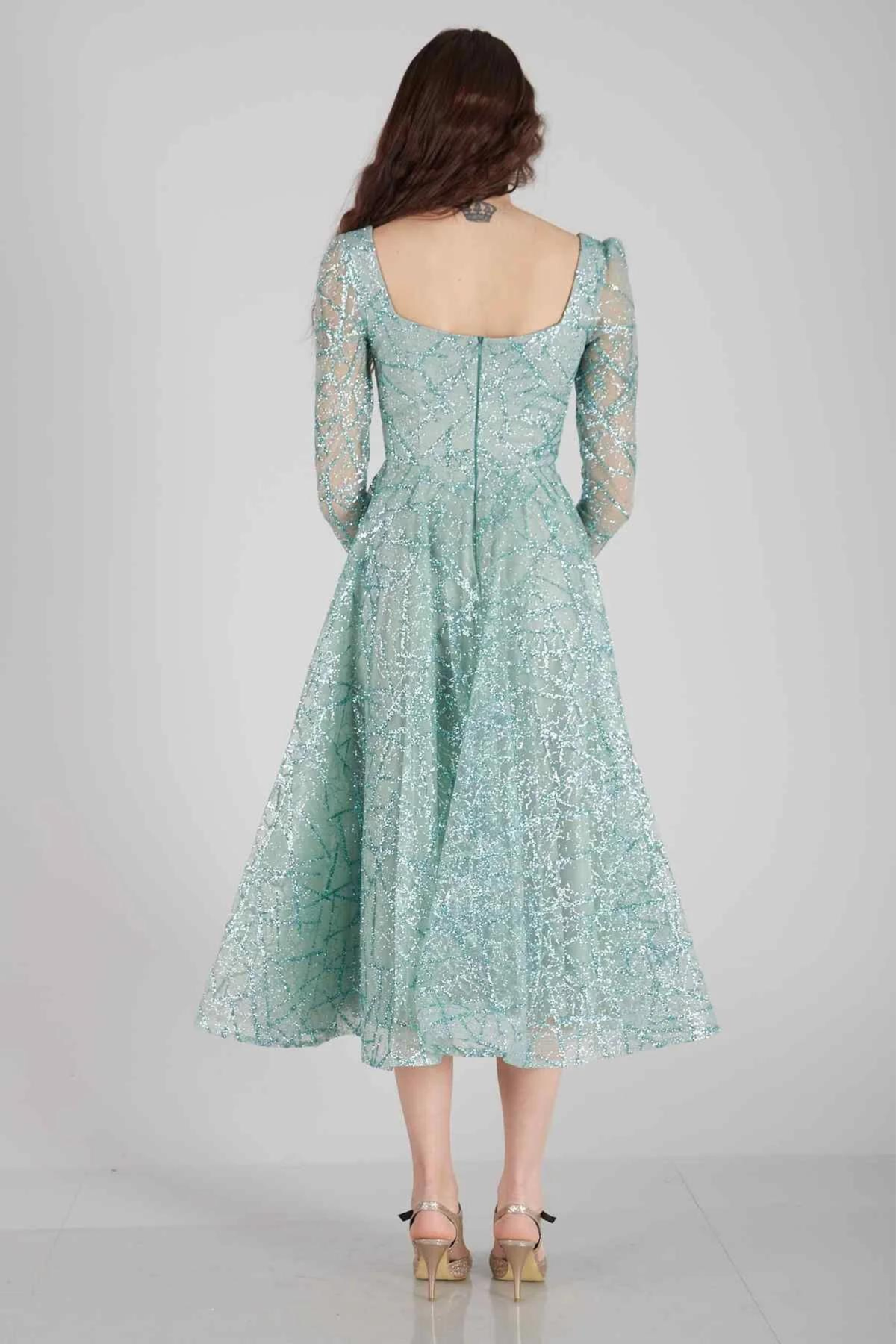Abito lungo svasato verde menta in tulle con trama glitterata e maniche lunghe, prodotto Moda-Mania.