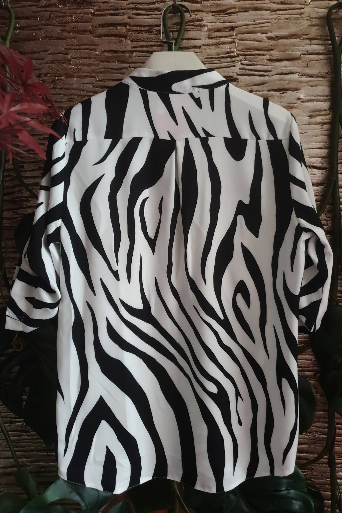 Blusa bianca zebrata Moda-Mania con maniche tre quarti e bottoni dorati, vista frontale su sfondo neutro.