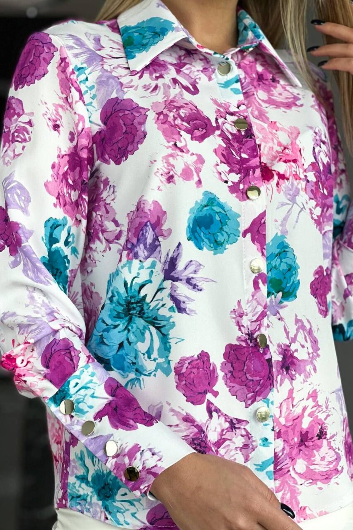 Camicia elegante bianca Moda-Mania con fantasia floreale turchese, magenta e viola, bottoni dorati, tessuto leggero e dettagli raffinati