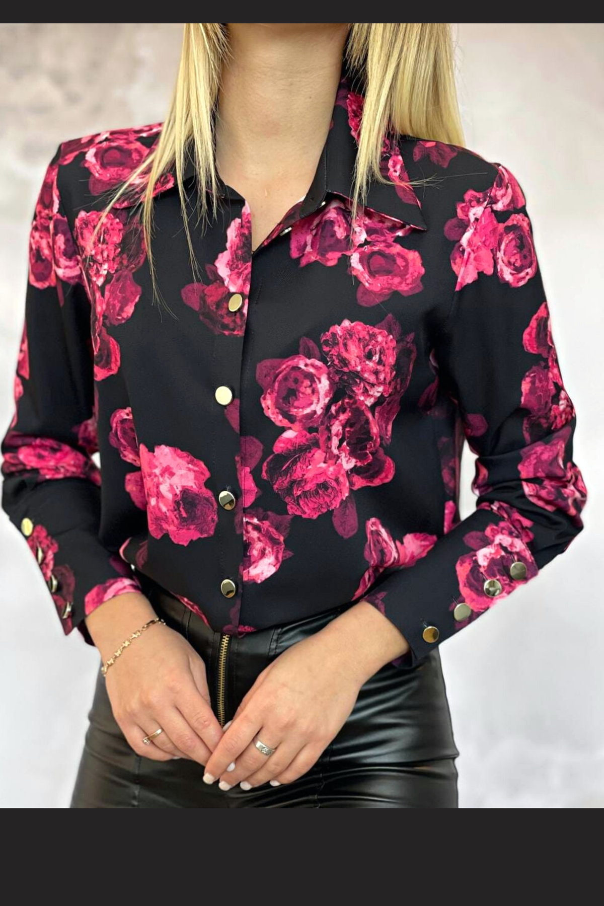 Camicia elegante nera Moda-Mania con fantasia floreale fucsia e bottoni dorati, dettaglio di moda e stile femminile.