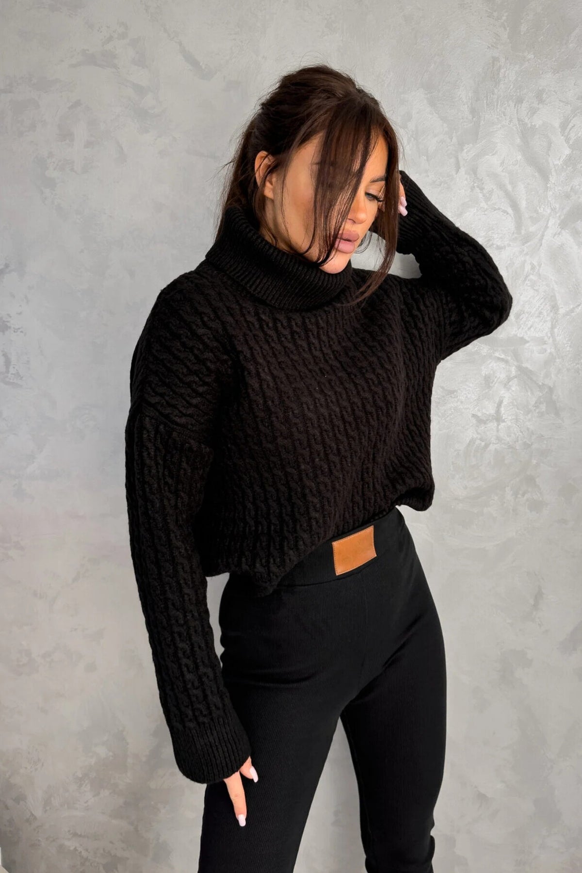 Maglione oversize nero in filato morbido con trecce, collo alto e polsini a coste, prodotto da Moda-Mania.