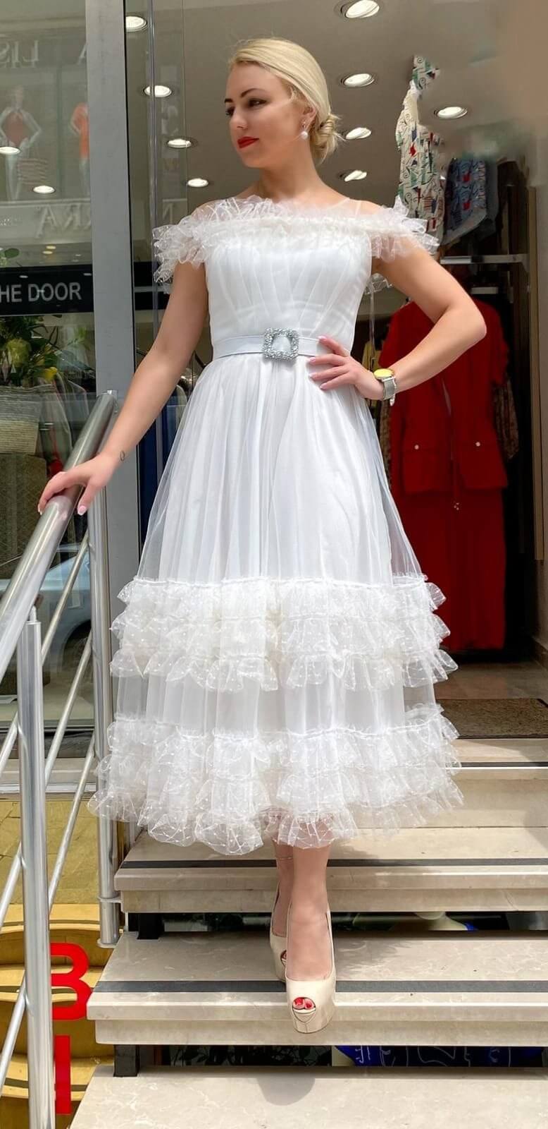 Abito midi svasato bianco in tulle Moda Mania con cintura, dettagli eleganti e accessori inclusi, vista frontale.