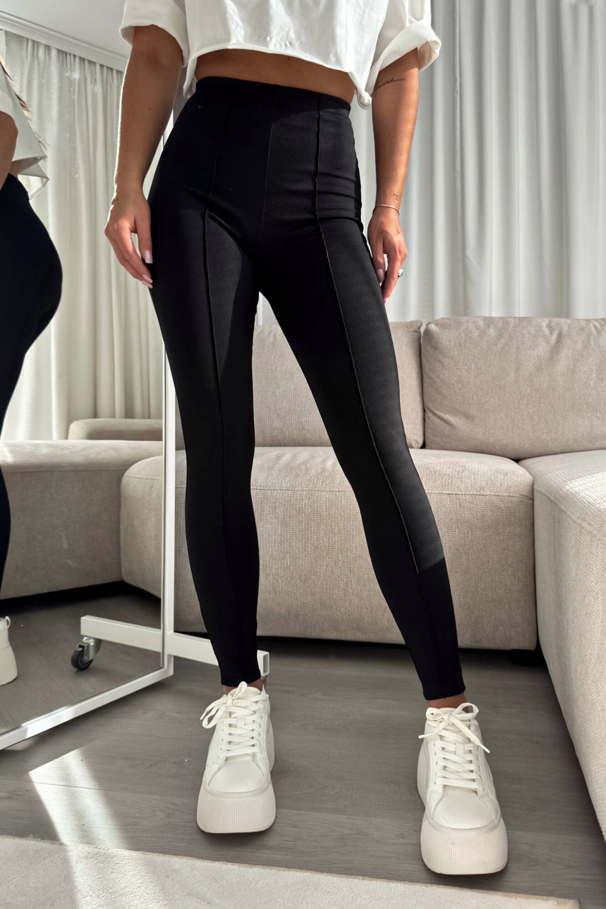 Leggings neri aderenti in cotone spesso elasticizzato a vita alta con cuciture longitudinali, da Moda-Mania, visibili in dettaglio.