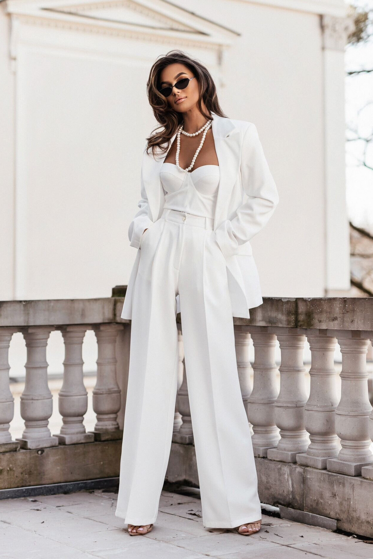 Pantaloni lunghi bianchi a palazzo con tasche laterali e vita medio alta, firmati Moda-Mania, visibili in primo piano.