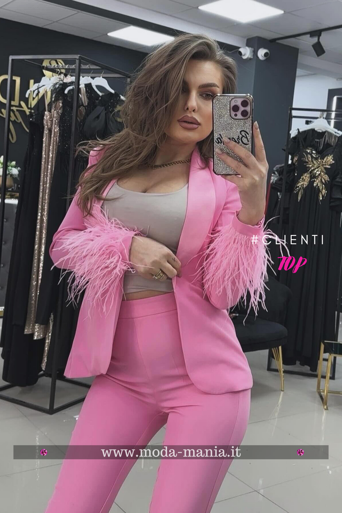Completo tailleur rosa Bby con giacca accessoriata con piume e pantaloni a sigaretta, abbigliamento elegante e alla moda.