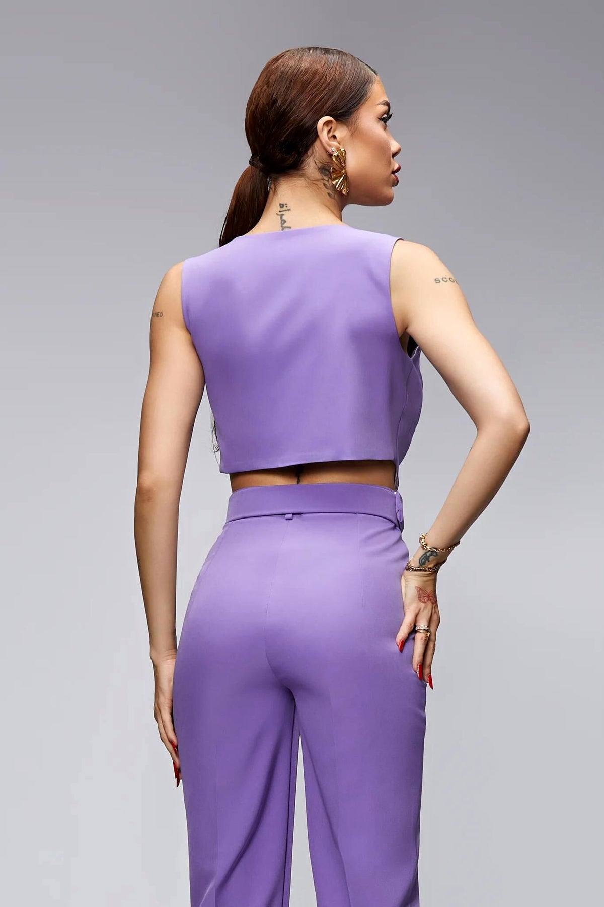 Salopette elegante lilla lavanda Bby con cintura, vestibilità raffinata e dettagli accessoriati, perfetta per occasioni speciali.