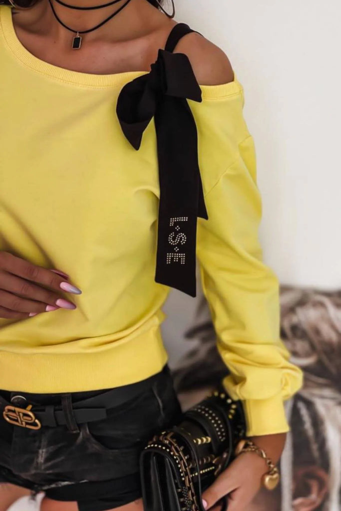 Maglia gialla in cotone a manica lunga con fiocco nero decorativo su una spalla