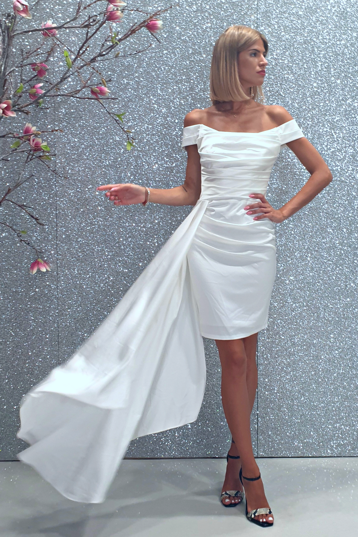 Abito corto bianco a barchetta in taffetà Moda-Mania con strascico laterale e pieghe, perfetto per occasioni eleganti.
