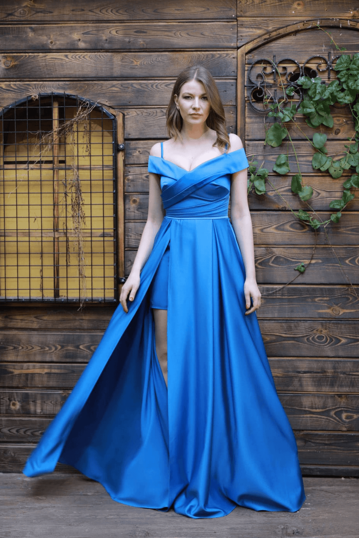 Abito lungo svasato blu celeste in taffetà con scollo a barchetta e spacco laterale, moda Moda-Mania, elegante e femminile.