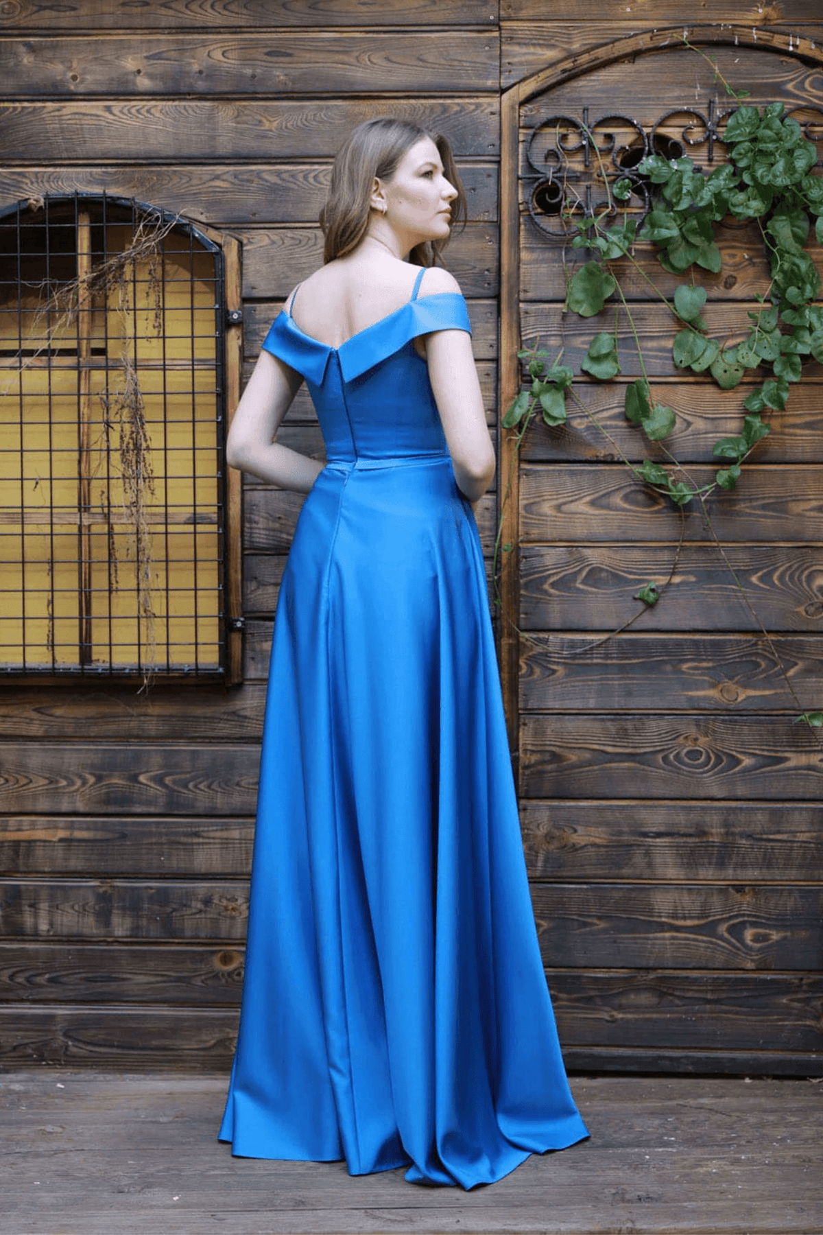 Abito lungo svasato blu celeste in taffetà di Moda-Mania, con scollo a barchetta e spacco laterale, visibile in dettaglio.