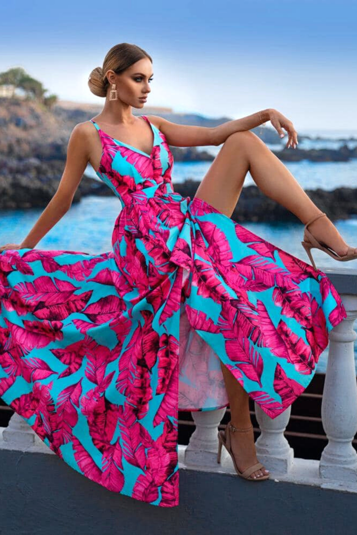 Abito lungo svasato estivo celeste con fantasia foglie fucsia e spacchi laterali, firmato Moda-Mania.