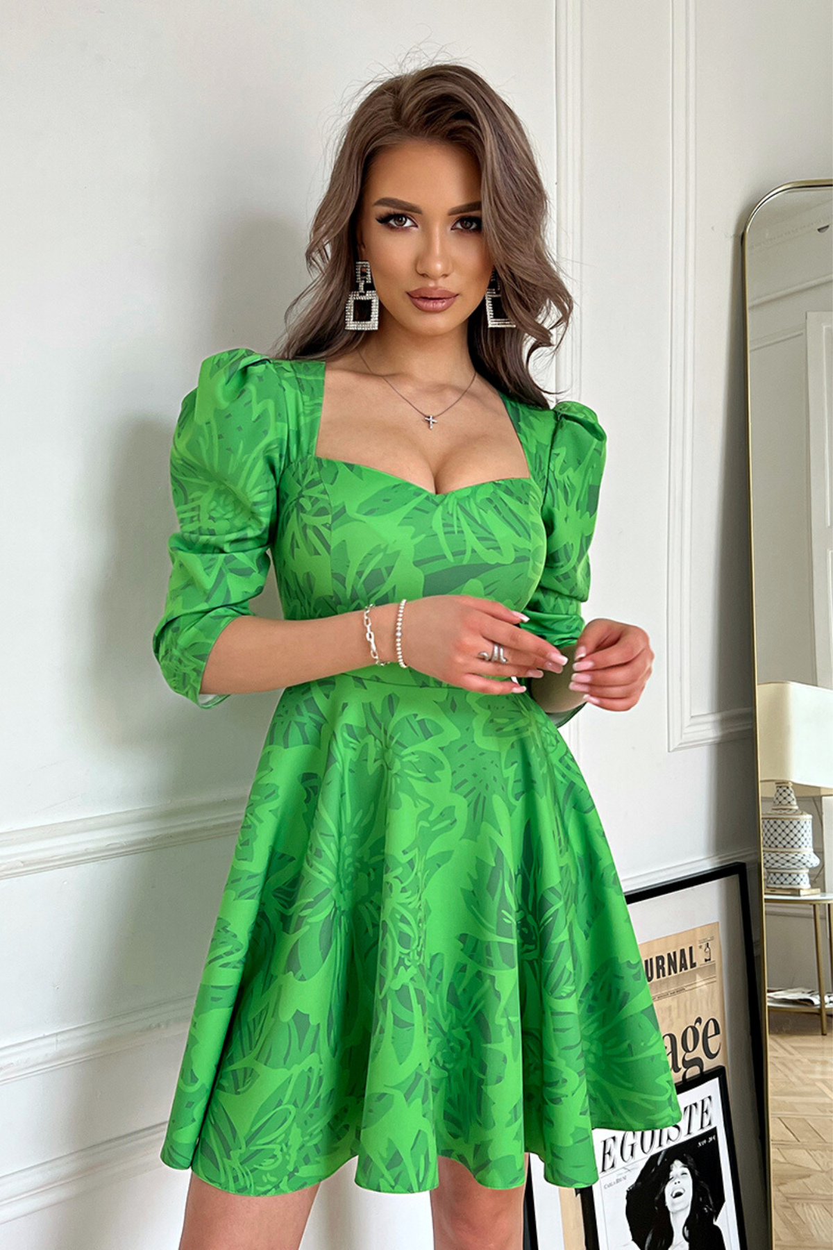 Abito svasato verde con fantasia floreale, scollo a V e maniche tre quarti a sbuffo, firmato Moda-Mania.