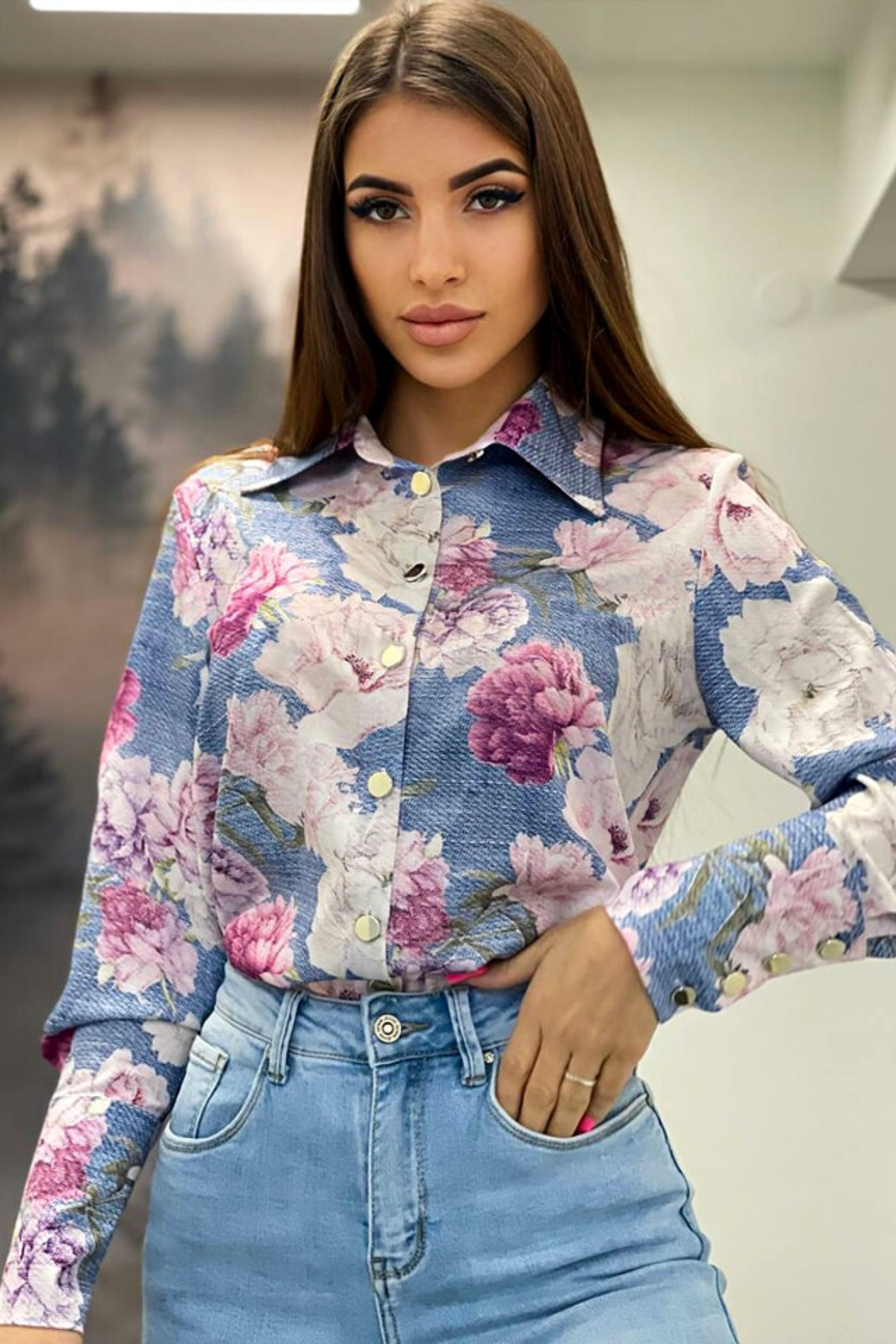 Camicia elegante bianca Moda-Mania con fantasia floreale rosa e bottoni dorati, tessuto leggero e stile raffinato.