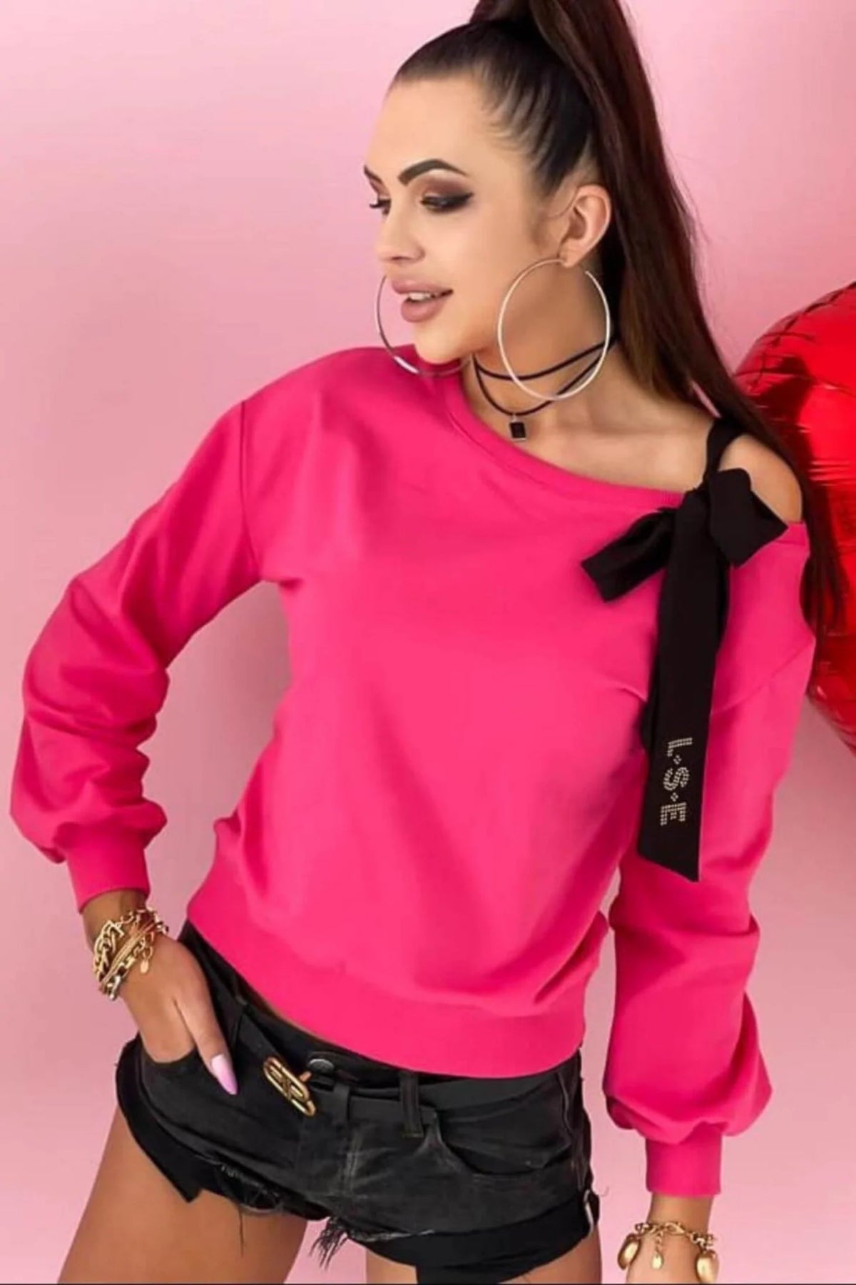Maglia fucsia in cotone a manica lunga con fiocco nero decorativo su una spalla, stile denim e sportivo di Moda-Mania.