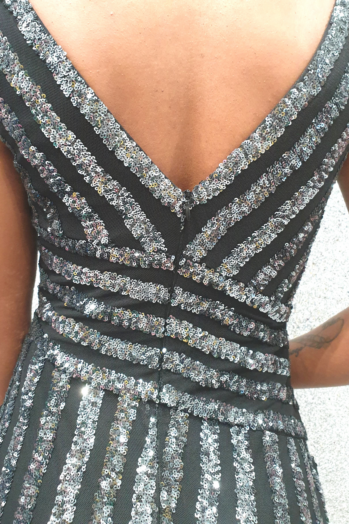 Abito a tubino a tre quarti Moda Mania nero con fantasia righe e paillettes argento, profondo scollo a V, vestibilità elegante.