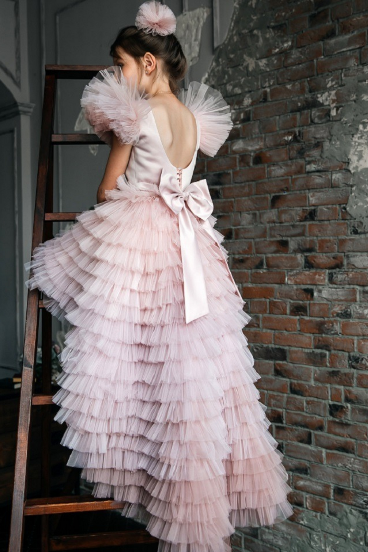 Abito rosa per bimba Moda-Mania con maniche a ventaglio, gonna in tulle multi volants e strascico staccabile, perfetto per occasioni speciali.