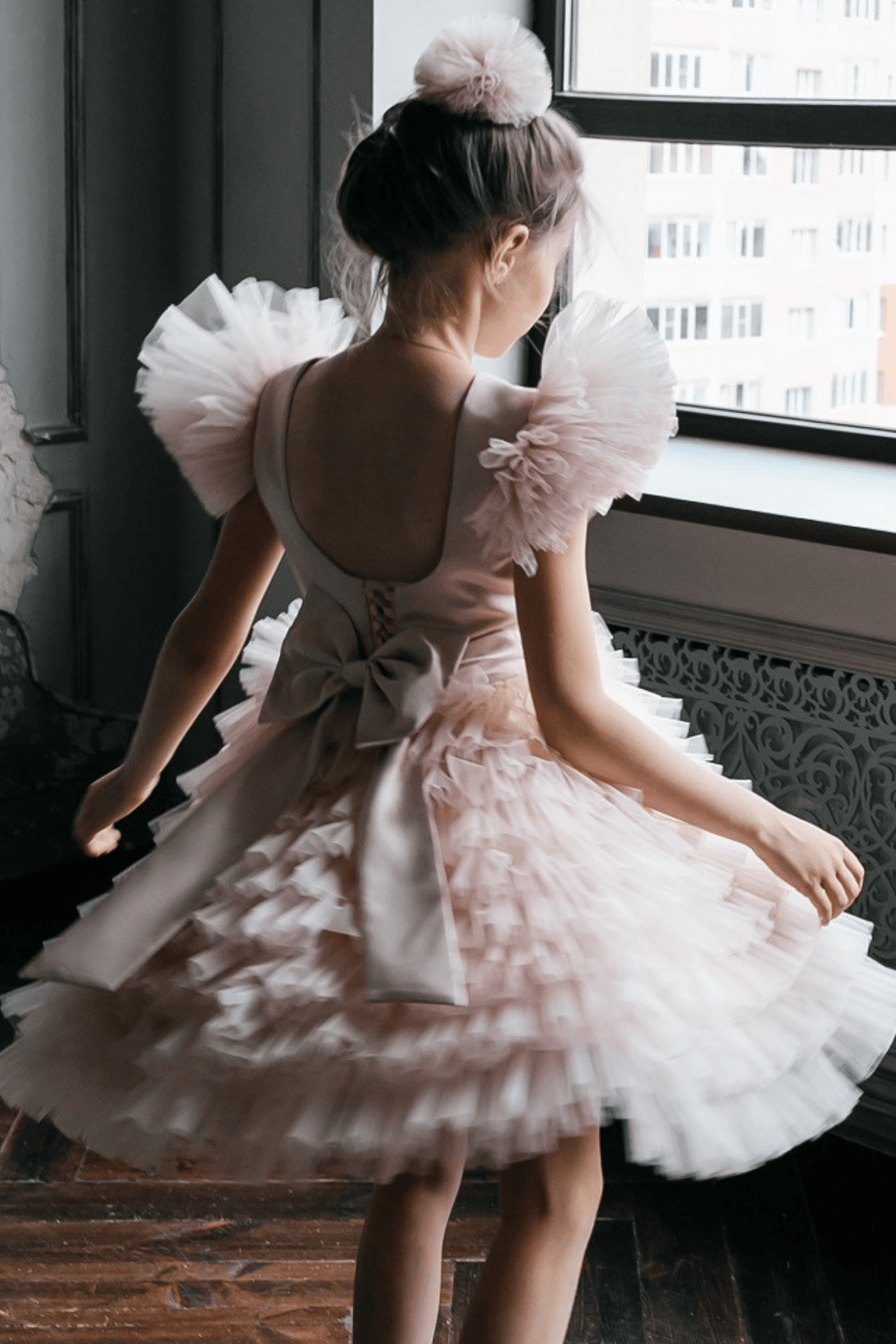 Abito rosa per bimba Moda-Mania con maniche a ventaglio, gonna in tulle multivolants e strascico staccabile, adatto a occasioni speciali.
