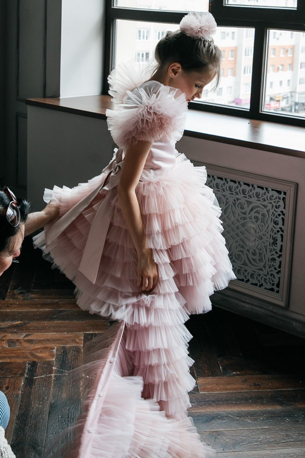 Abito rosa per bimba Moda-Mania con maniche a ventaglio, gonna in tulle multivolants e strascico staccabile.