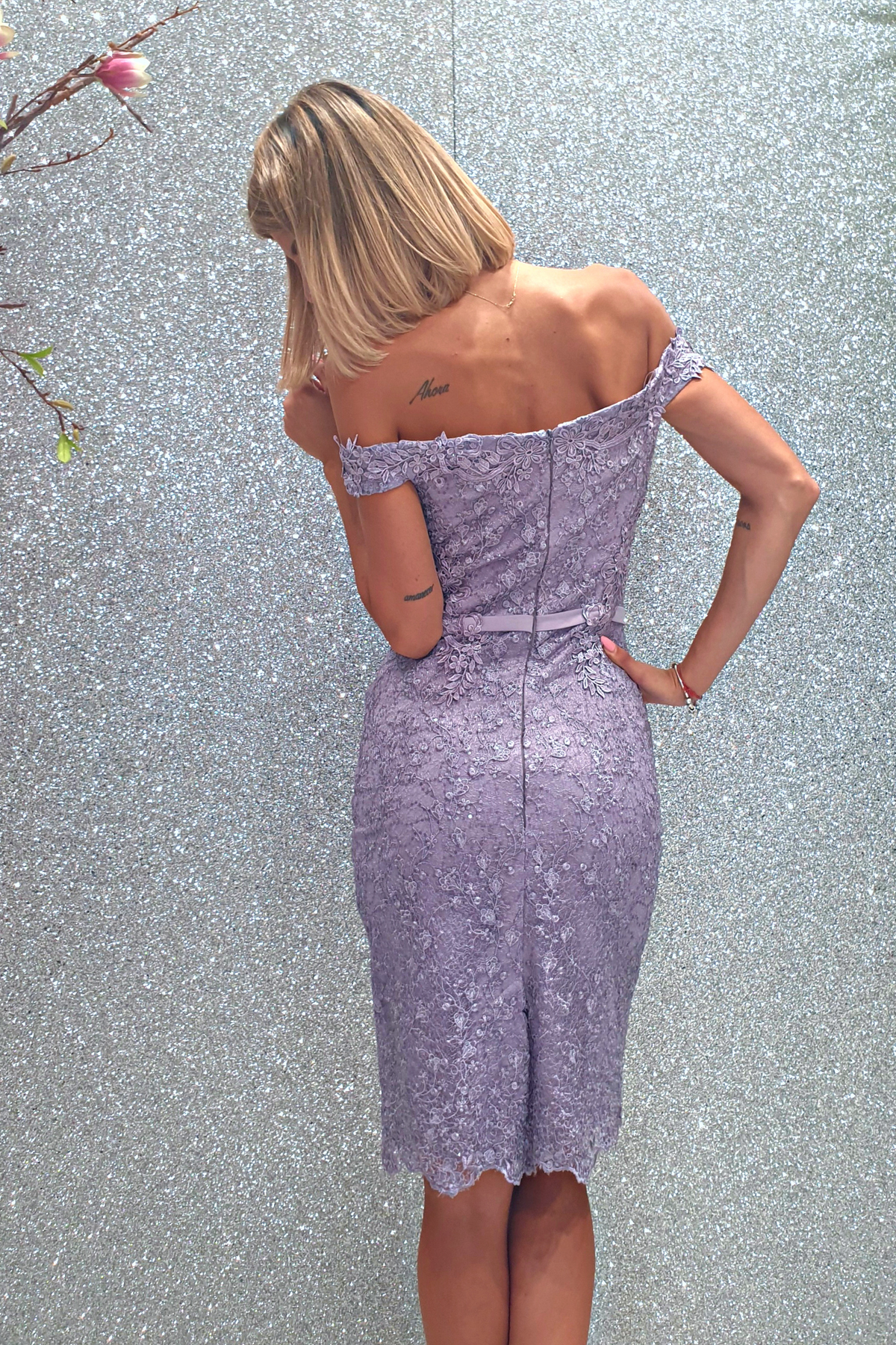 Abito corto lilla in merletto floreale con applicazioni strass e scollo a barchetta, marca Moda-Mania.