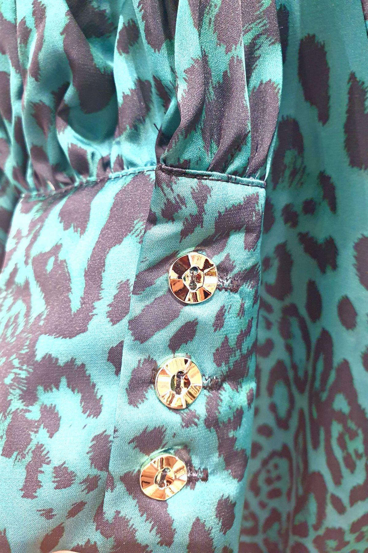 Camicia elegante Moda-Mania a fantasia leopardata verde con maniche a sbuffo e bottoni gioiello, dettagli raffinati.