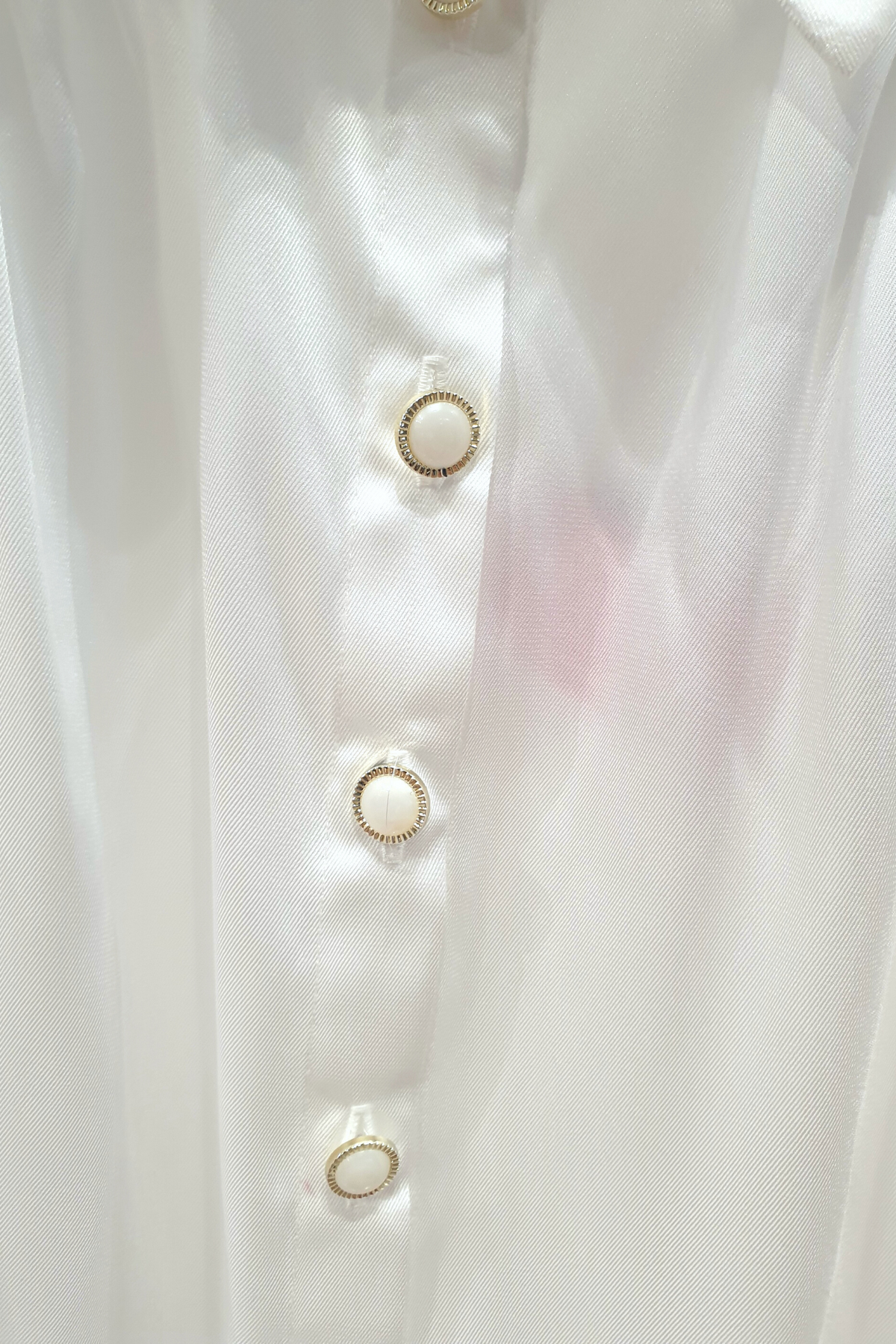 Camicia elegante bianca Moda-Mania in tessuto satinato con maniche a sbuffo e bottoni gioiello, dettaglio frontale.