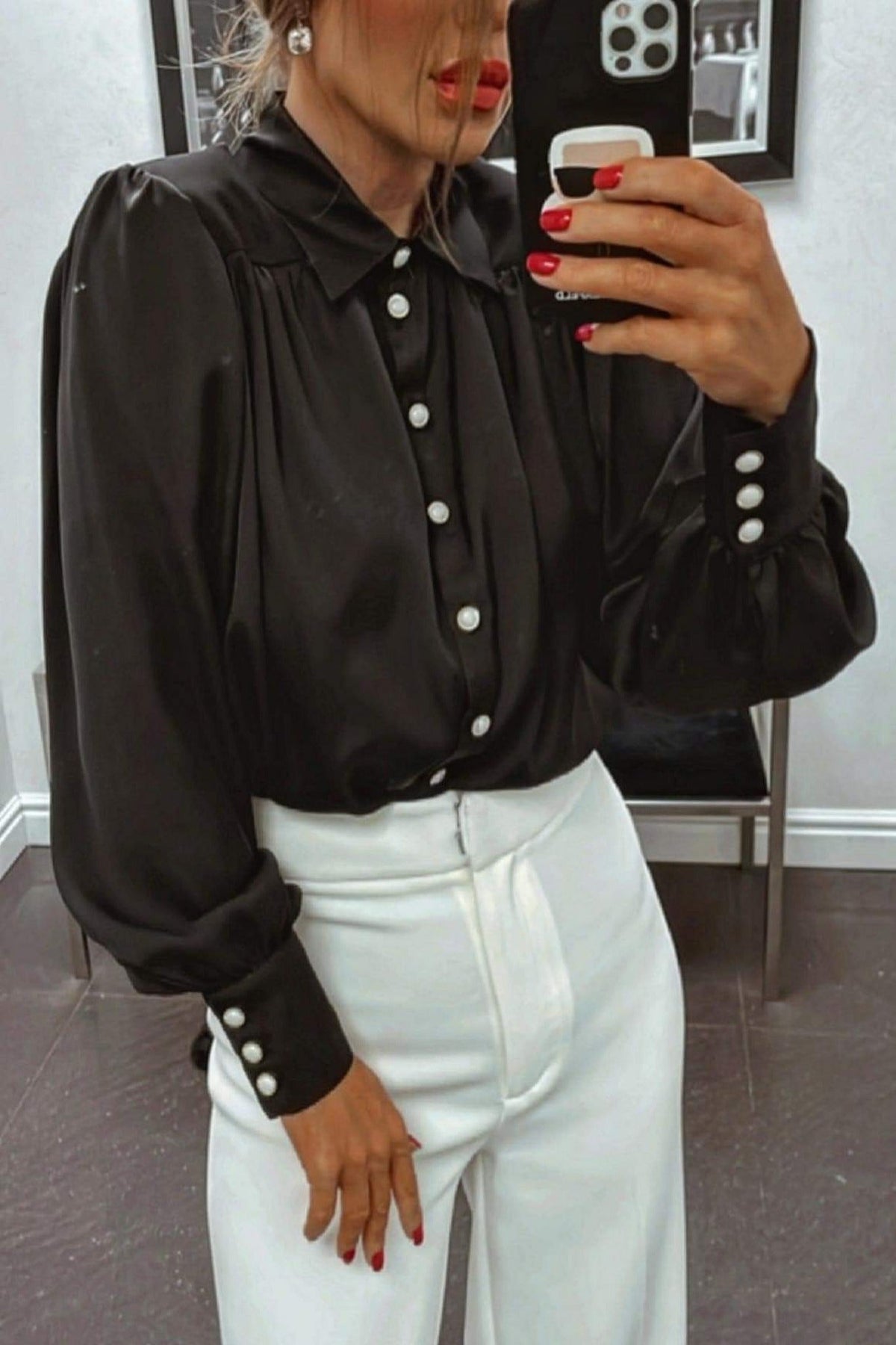 Camicia elegante nera Moda-Mania in tessuto satinato con maniche a sbuffo e bottoni gioiello bianchi, dettagli raffinati.
