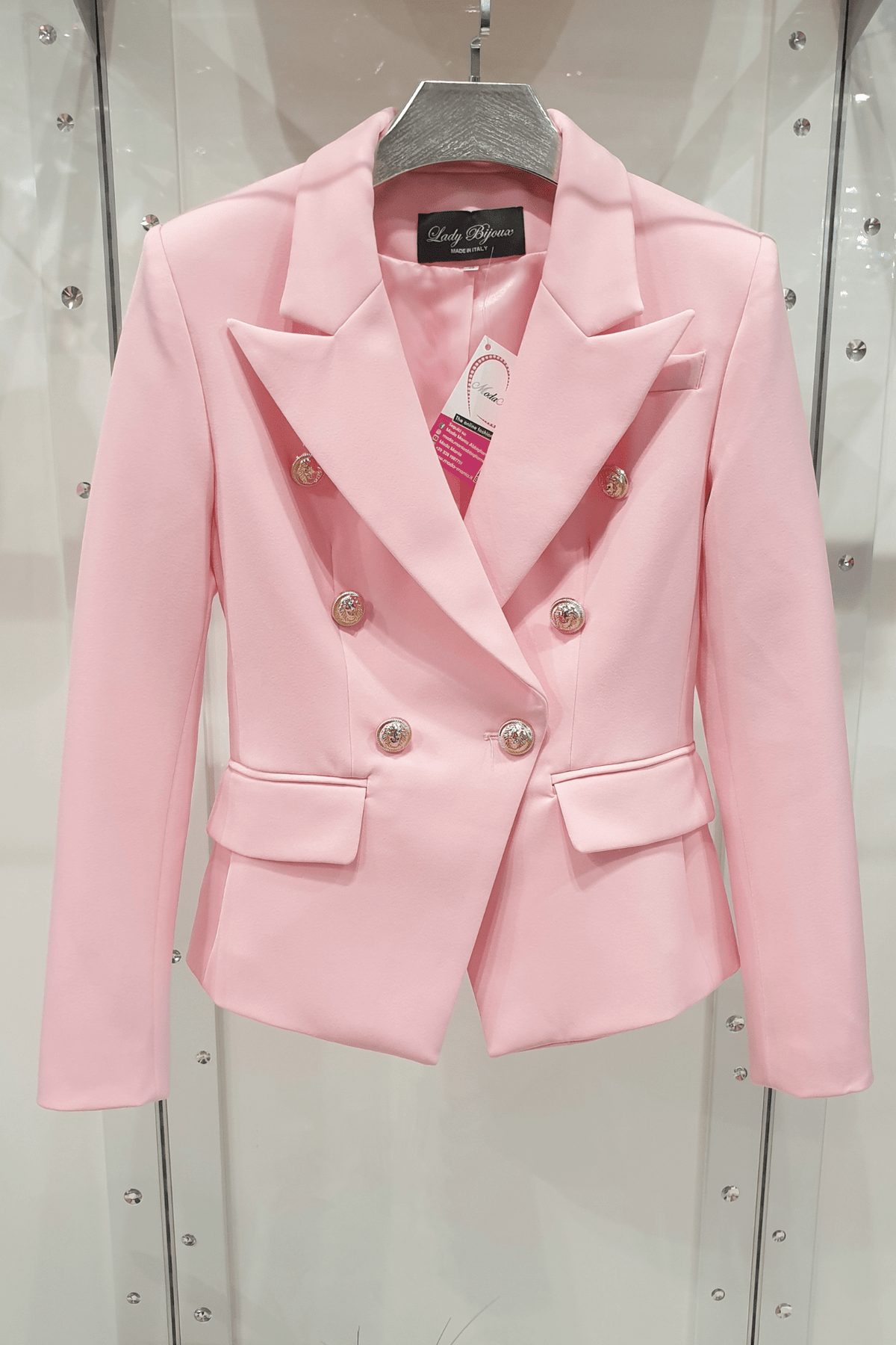 Giacca da tailleur doppiopetto rosa Moda-Mania, foderata, accessoriata con bottoni dorati decorativi, stile elegante e femminile.