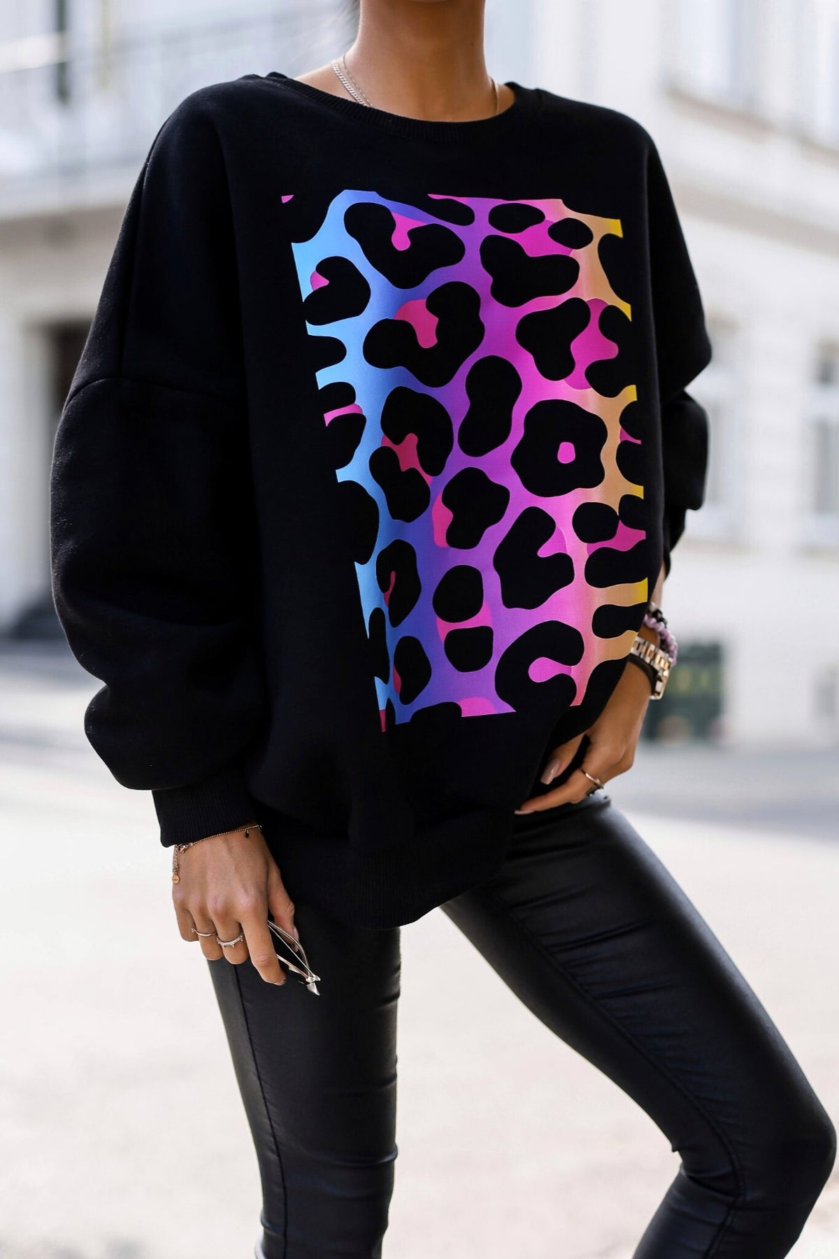 Maglia felpa oversize nera in cotone con stampa maculata multicolore e polsini elasticizzati, adatta a look casual e comodi