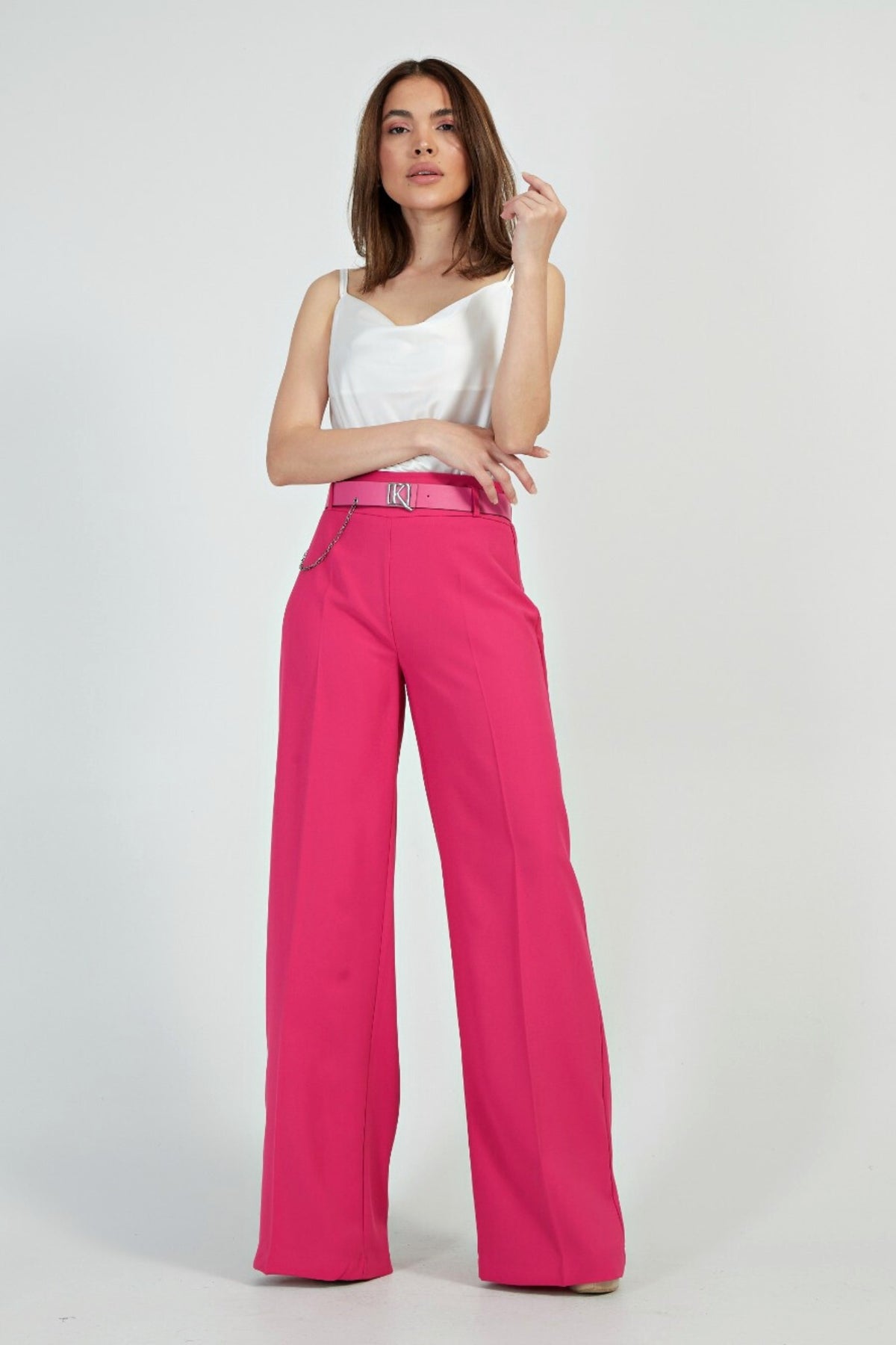 Pantaloni fucsia a gamba larga con vita alta e cintura, marca Moda-Mania, dettaglio di stile e accessoriata in foto.