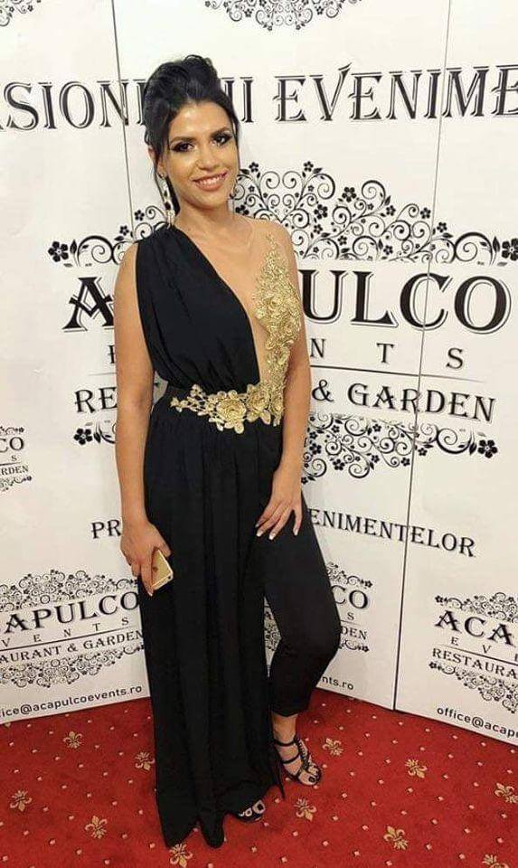 Salopette elegante nera Bby con corpetto in tulle a fiori dorati e strascico laterale, outfit sofisticato e alla moda.