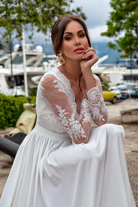 Abito lungo svasato bianco con spacco laterale e corpetto in tulle ricamato, firmato Moda-Mania.