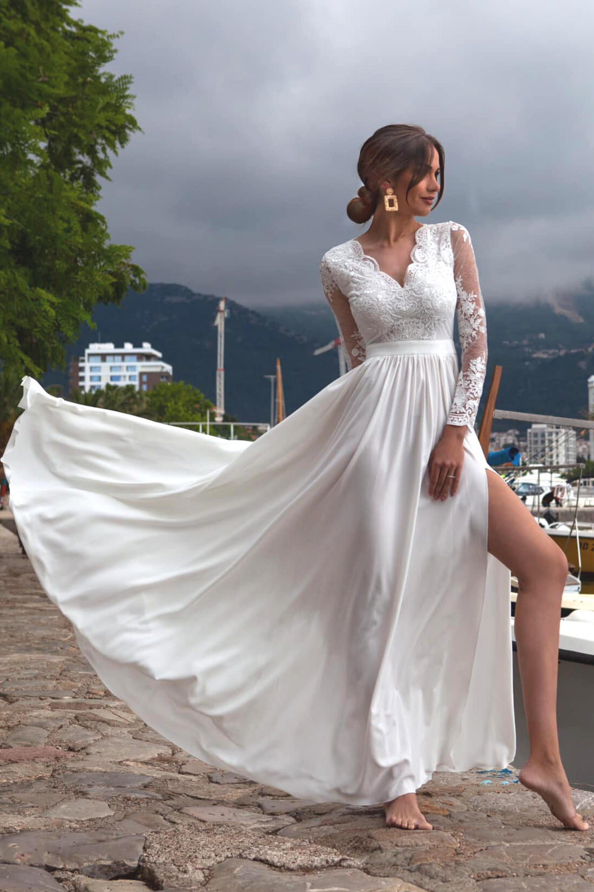 Abito lungo svasato bianco Moda-Mania con spacco laterale e corpetto in tulle ricamato, elegante e femminile.