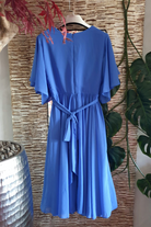 Abito svasato blu cobalto per donne curvy con maniche a campana, cinturino in vita e accessorio, lungo e elegante.