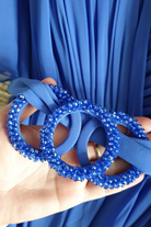 Abito lungo svasato per donne curvy in tessuto lavanda viola con maniche a campana e cinturino in vita con accessorio.