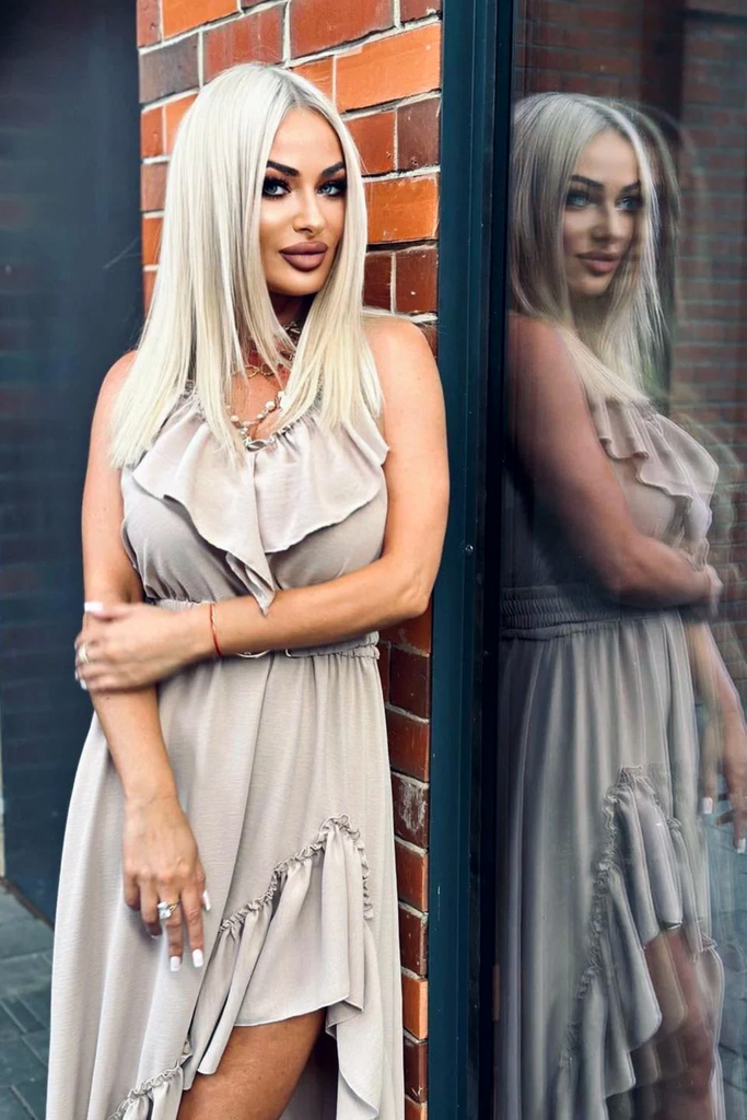 Abito beige chiaro corto davanti e lungo dietro con cintura elasticizzata e rifinito da volants