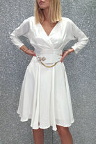 Abito bianco svasato con maniche lunghe e cintura, abiti corti Moda-Mania, dettaglio di tessuto e accessori.