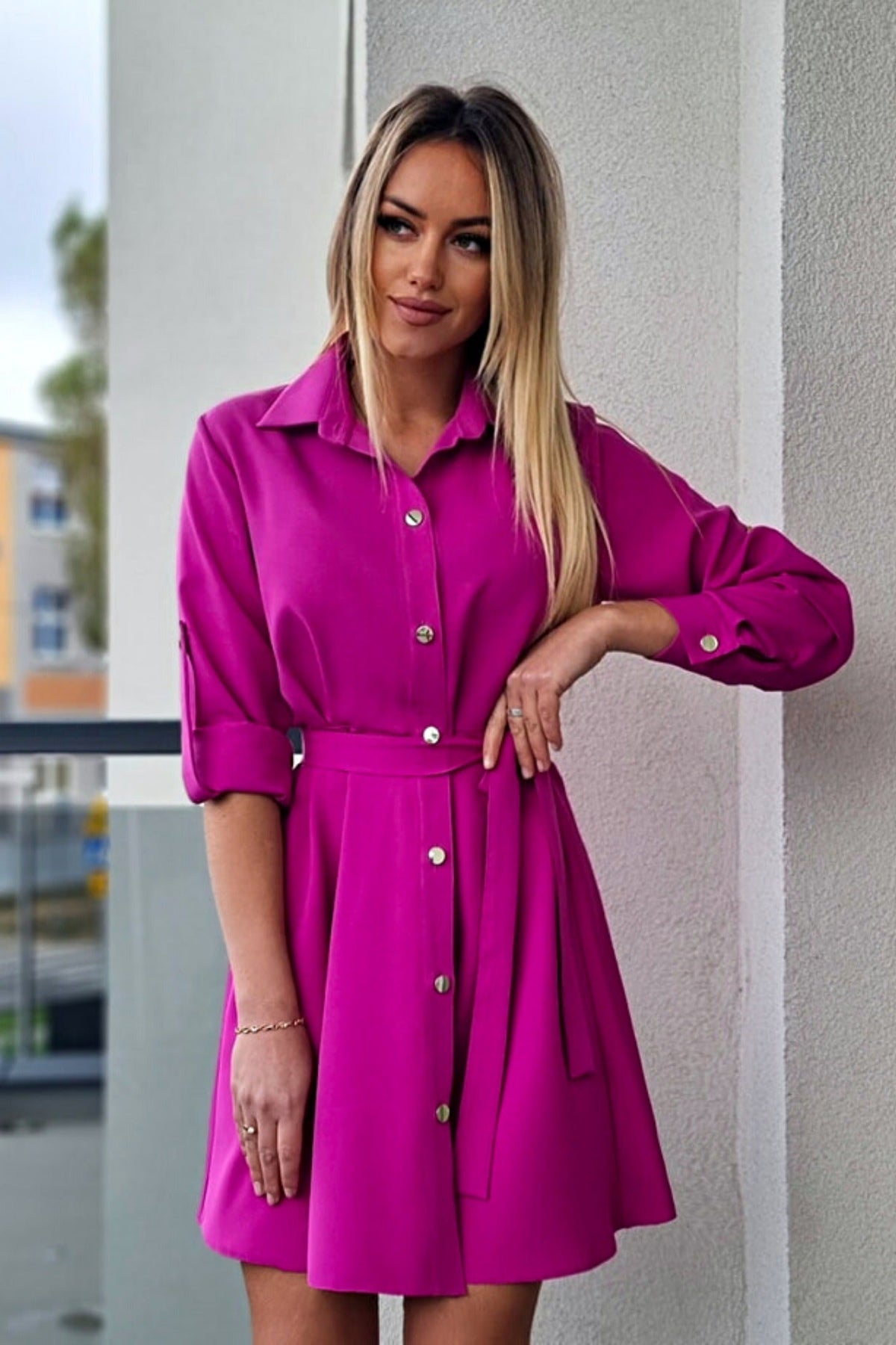 Abito camicia svasato magenta con bottoni dorati e cinturino, abiti corti moda-mania, tessuto leggero e dettagli eleganti.