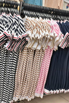 Abito casual corto a righe orizzontali bianco e beige in cotone con scollo a V e orli rifiniti con nastro decorativo.