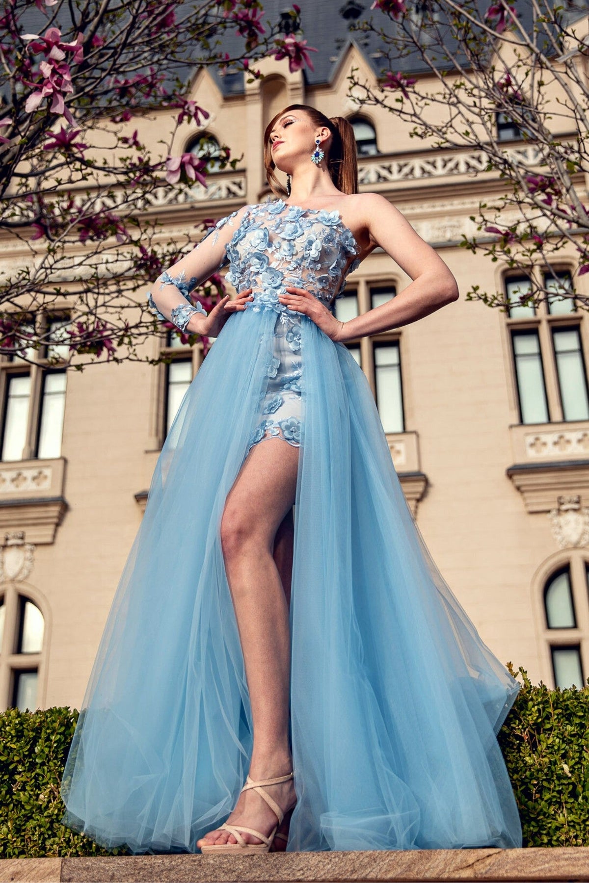 Abito corto celeste a fiori con manica singola e gonna lunga in tulle ampia, marca Moda-Mania, vestito elegante e femminile.