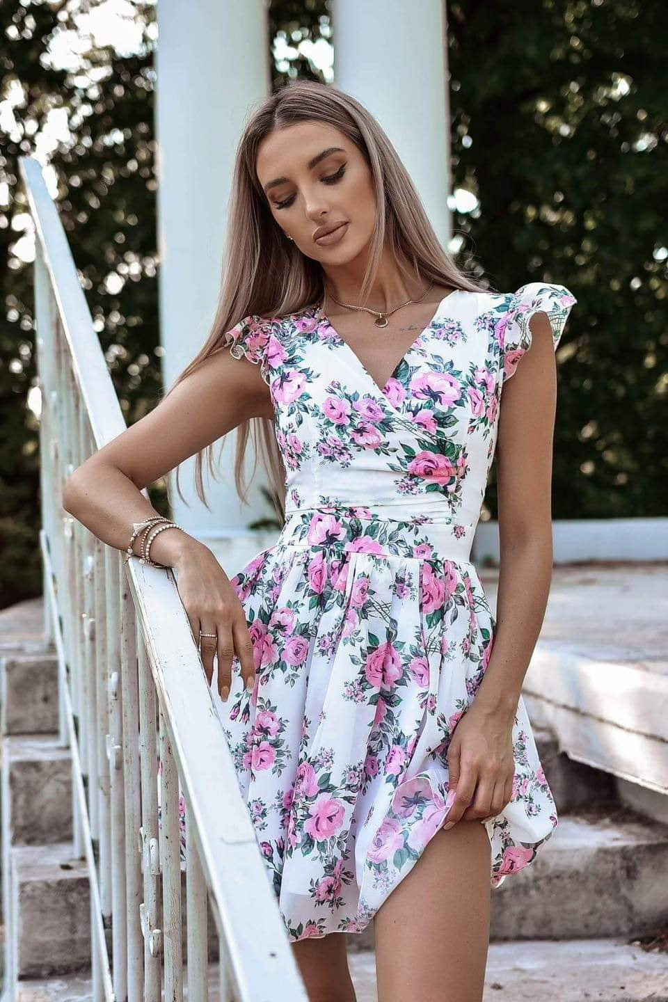 Abito corto estivo bianco svasato con fantasia floreale, scollo a V e piccole maniche, marca Moda-Mania.