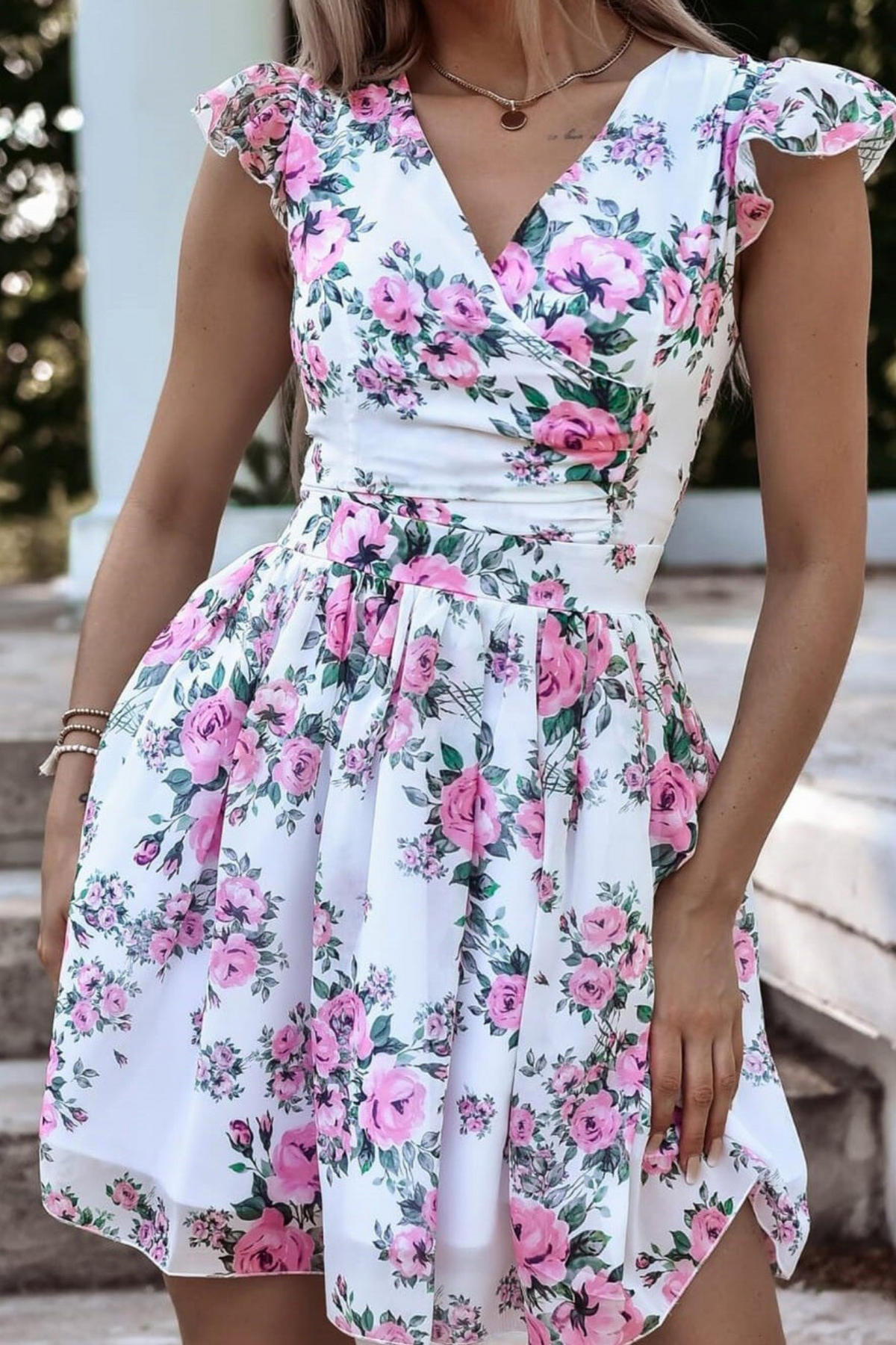 Abito corto estivo bianco svasato con fantasia floreale, scollo a V e piccole maniche, marca Moda-Mania.