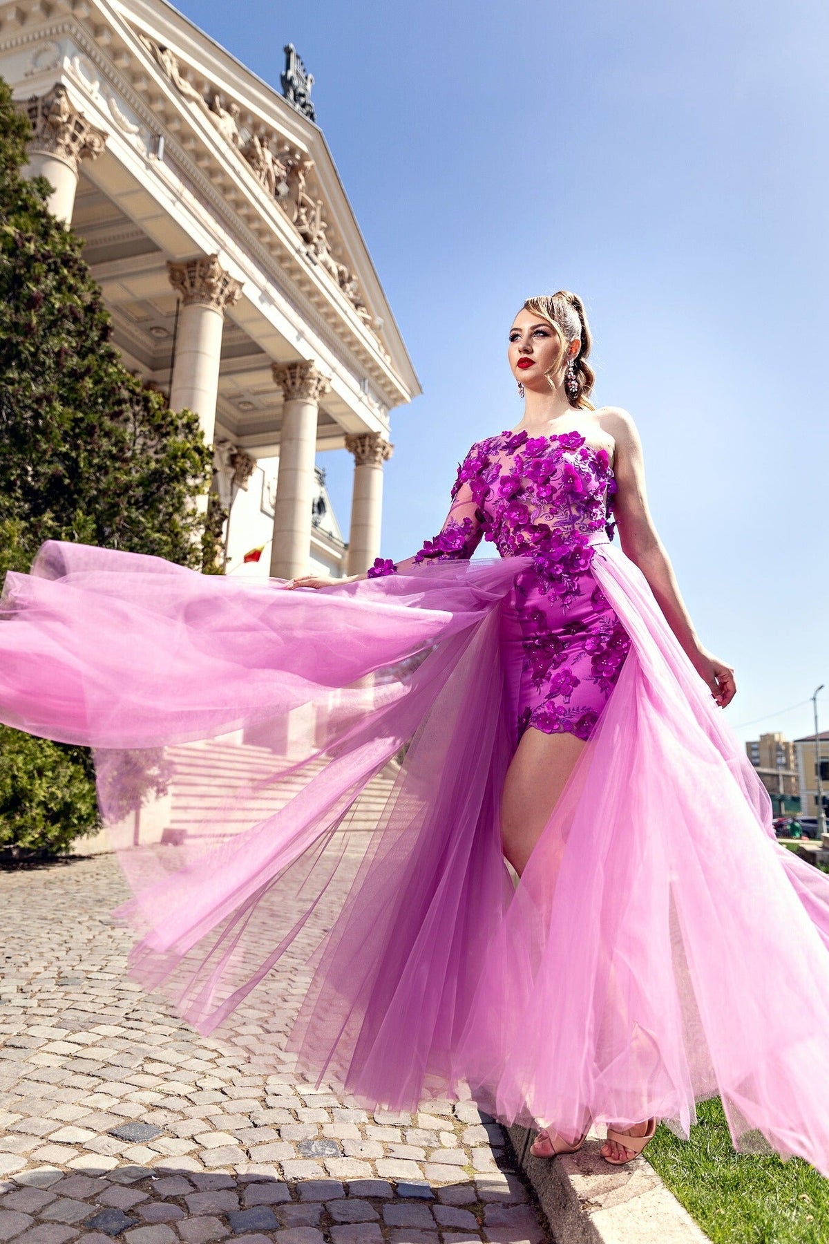Abito corto fucsia a fiori con manica mono, gonna lunga in tulle ampia, di Moda-Mania, visibile con dettagli floreali e tessuto leggero.