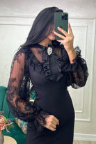 Abito corto nero linea dritta Moda-Mania con maniche in pizzo e spilla decorativa, stile elegante e femminile.