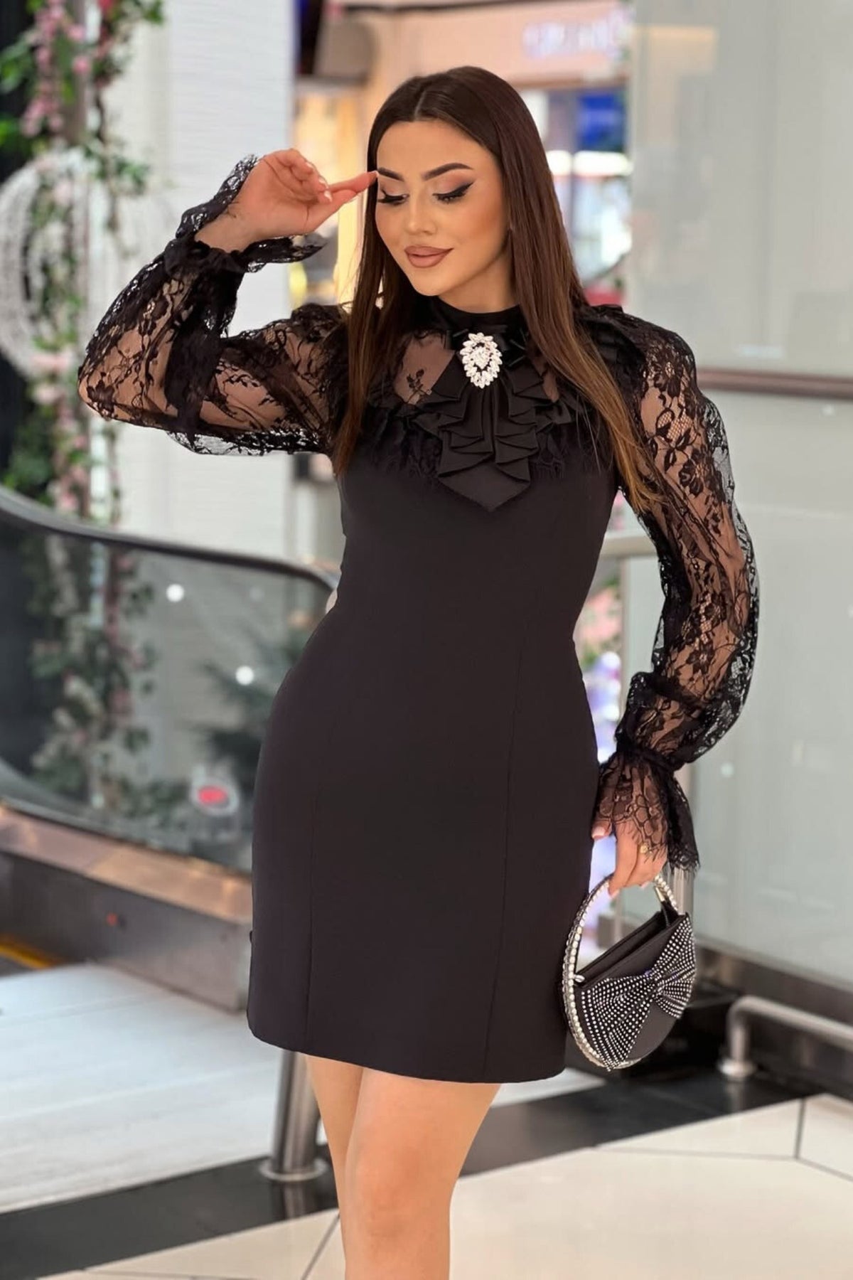 Abito corto nero linea dritta con maniche in pizzo e spilla decorativa, vestito elegante Moda-Mania, dettaglio in tessuto e accessori