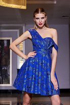 Abito corto svasato blu elettrico con fantasia glitterata e spalla cadente, firmato Moda-Mania, perfetto per occasioni eleganti.