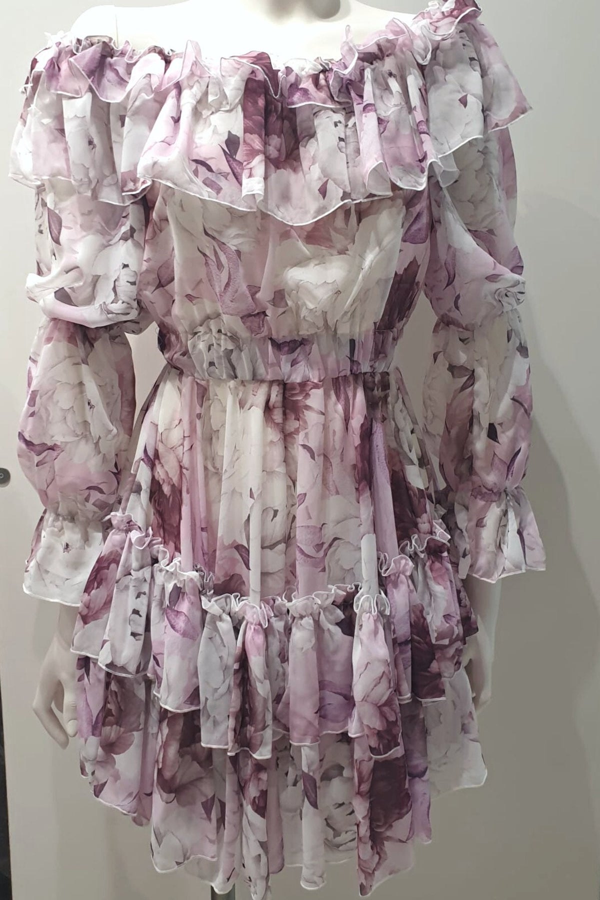 Abito corto svasato estivo bianco con fantasia floreale viola e rosa, dettagli multivolt e stile leggero di Moda-Mania.