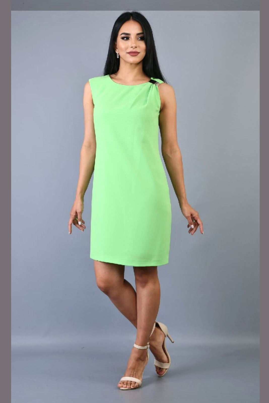 Abito corto verde lime fluo di Moda-Mania con linea dritta e accessorio dorato su una spalla, tessuto brillante e moderno.