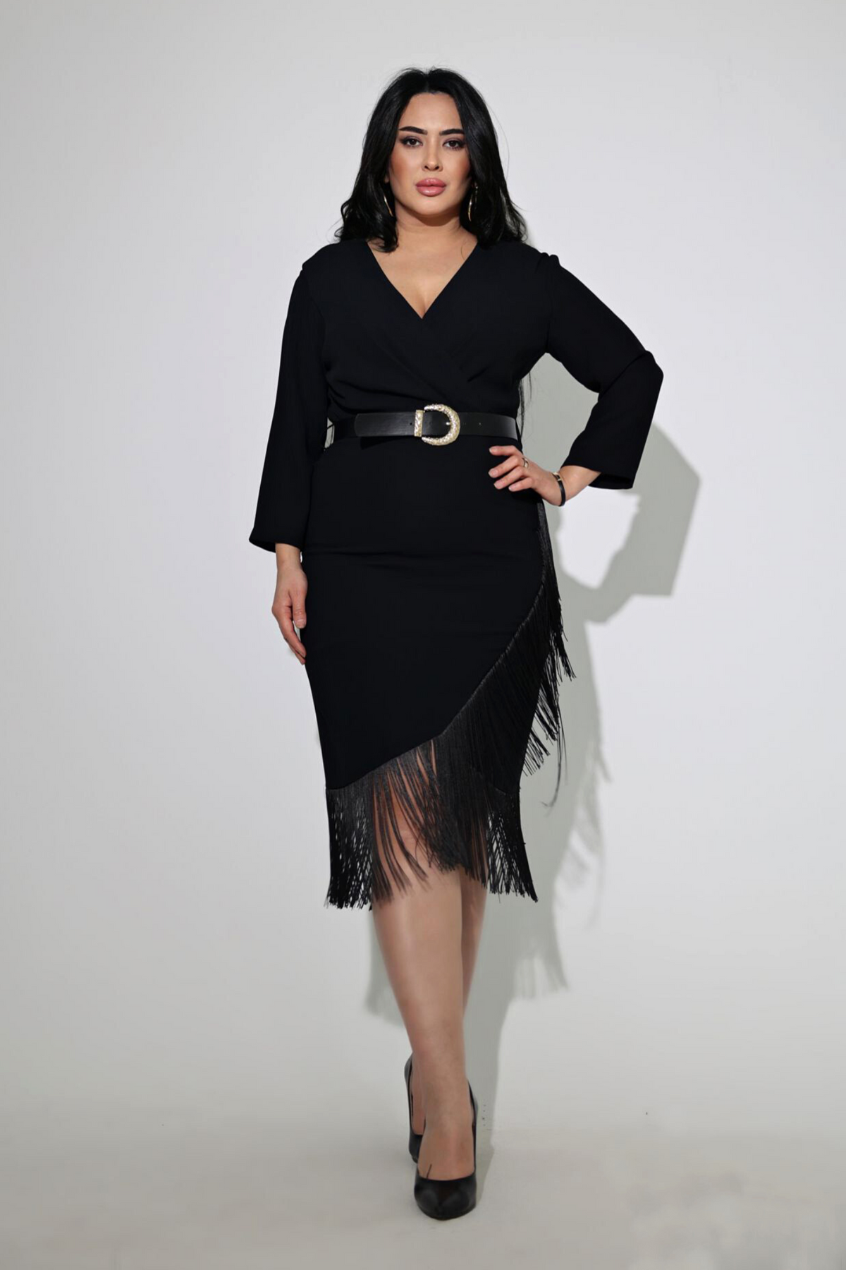 Abito midi curvy nero asimmetrico con frange decorative e cintura, firma Moda-Mania, vestibilità elegante e moderna.